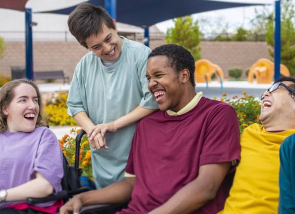 Young people with special educational needs laughing with each other in social setting.