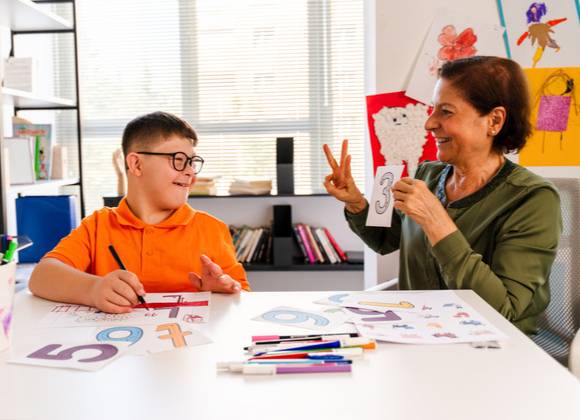 Child with teacher having individual tuition in educational setting.