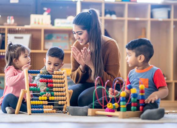 Pre-school children with teacher in educational setting.